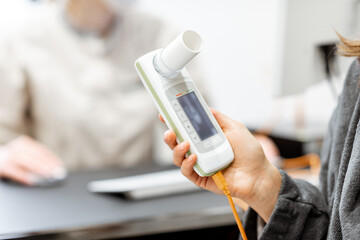 Patient holding spirometer - obrazy, fototapety, plakaty