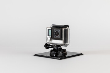 Action camera, compact sports camera in waterproof housing and on stand to keep it stationary