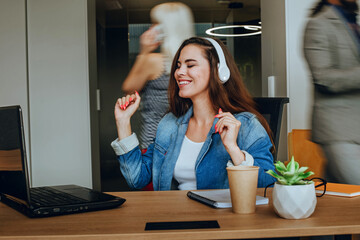 Attractive business woman in the headphones relaxing in office