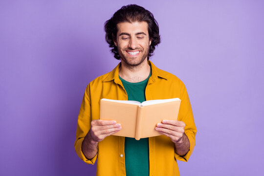 Photo of cheerful positive smile young man read book information isolated over violet color background