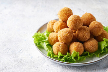 Fried cheese balls, appetizer with herbs and sauces in a plate on a gray table Copy space