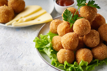 cheese balls, appetizer with herbs and sauces in a plate on a gray table