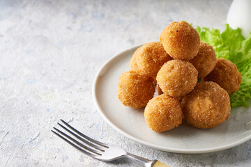 cheese balls, appetizer with herbs and sauces in a plate on a gray table