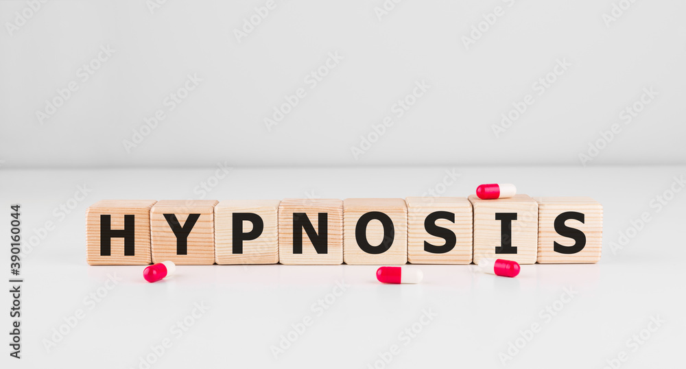 Poster hypnosis word made with building blocks with pills.