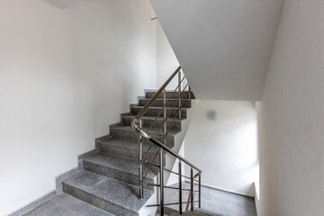 Modern stair case between floors. Stairs with metallic rail  in modern building