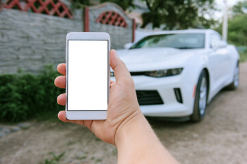 Mock Up Smartphone in man's hand, in the background a white car.