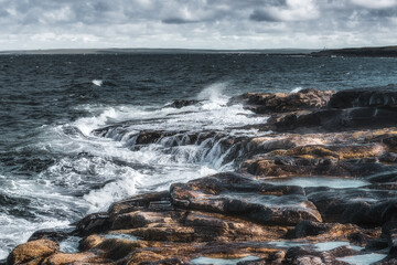 Waves of the Barents Sea on the bank of the Red Rocks on the Srednyi Peninsula. Russia, Murmansk region