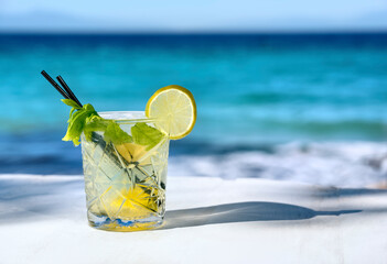 White mojito cocktail with lemon slice and ice on a sea background