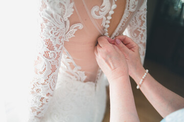 hands tying wedding dress