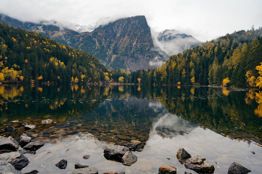Alpine lake of Piburger See in the Otztal valley in the Austrian Tyrol during autumn, colorful trees in the Alps