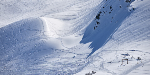 Panoramic view of the snowy mountain slope with ski tracks at Whistler resort in Canada.