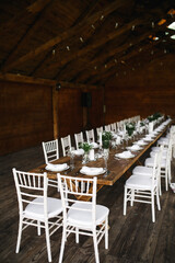 decorated wedding wood table with white chairs