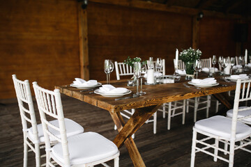 decorated wedding wood table with white chairs