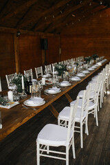 decorated wedding wood table with white chairs