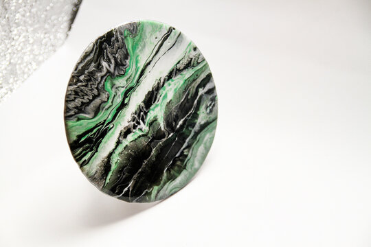 Close-up view of green, white and black epoxy resin marbles in circular piece