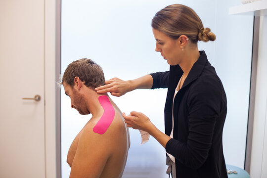 shoulder treatment with pink physio tape