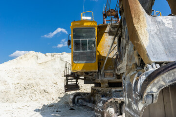 Large old yellow excavator at a construction site in a quarry. Industrial image.