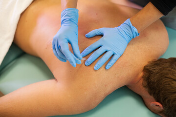 Doctor sticks needle into man's body on the acupuncture