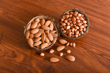 almonds, groundnut, peanut dry fruits and nuts in coconut shell background , Kerala India. mixed nuts background , layout of seeds, Protein fiber rich food diet muscle body building