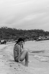 Chica joven sensual en la playa con biquini