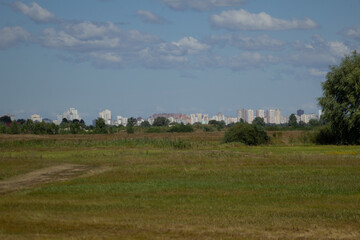 landscape with trees and clouds and the city in the background 