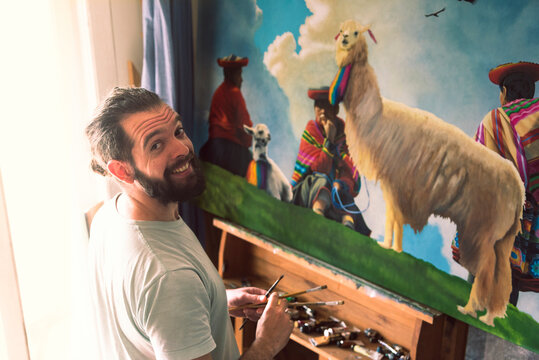 Male artist smiling while painting