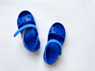 Baby blue rubber sandals on a white background.  Comfortable kids massage beach sandals.  Top view, isolate.