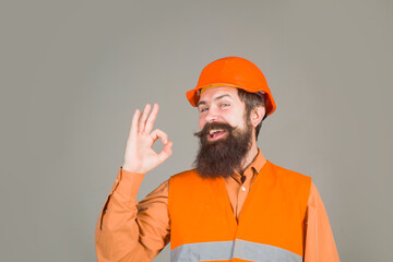 Bearded man in protective helmet shows sign ok. Man in hard hat. Construction worker in hardhat. Business, industry, technology. Builder concept.