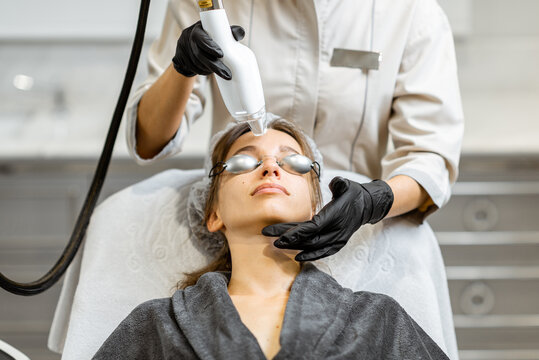 Portrait of a young woman during a facial rejuvenation treatment at medical SPA. LaseMD procedure concept