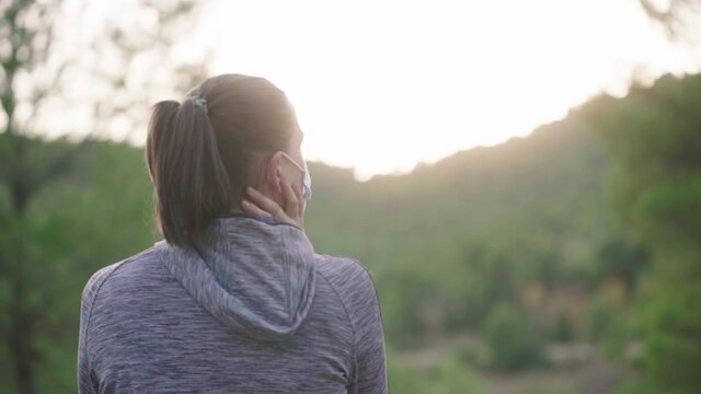 Girl Sitting With Face Mask Admiring The Trees And Vibrant Sunlight In The Morning. - medium shot