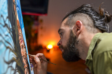 Fototapeta na wymiar Male artist painting with artificial light