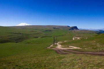 Beautiful alpine meadows on a sunny day with a view of the snowy mountain Elbrus