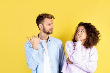 Man and african american woman standing on yellow background