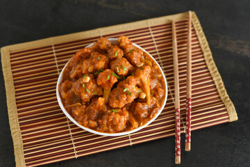 Gobi Manchurian dry and with gravy , Gobi 65 popular street food Delhi India made of cauliflower florets, Veg Manchurian chilly gobi Indo Chinese cuisine side dish of paratha , chapati , roti , Pulao