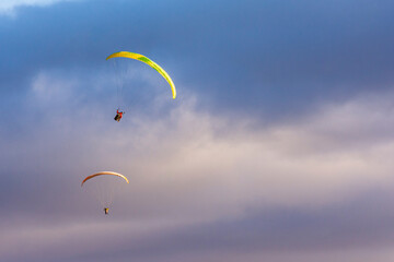 Paragliders against snow-capped Andes mountains during winter season in Esquel, Patagonia, Argentina