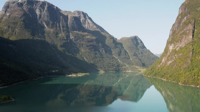 Glacial Lake Under Summer Sun. Aerial View of Oldevatnet, Norway.  Alpine Water Under Mountain Hills and Briksdalbreen Glacier, Drone Shot