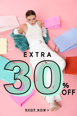 overhead view of young woman in blue faux fur jacket sitting near shopping bags and extra 30...