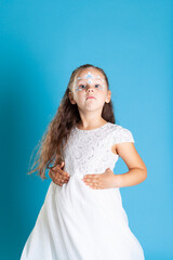 portrait of a surprised girl in a white Princess dress and snow Queen makeup with her hands on her...
