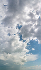 Fantastic clouds against blue sky, vertical panorama
