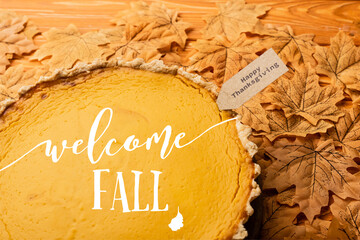 pumpkin pie with welcome fall lettering and happy thanksgiving tag on leaves