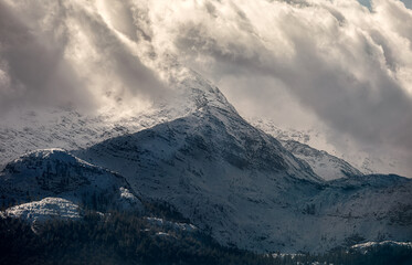 stormy snowstorm clouds over mountain peak