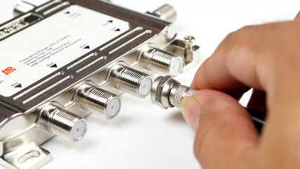 Male hand to F type adapter connector on isolated background.