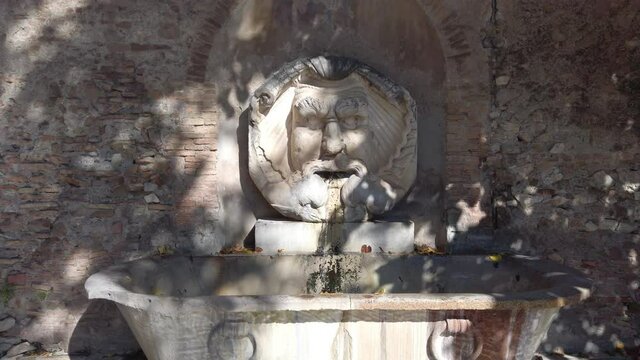 Monumental fountain called Fontana del Mascherone di Santa Sabina located in Rome, slow motion with dolly forward move.