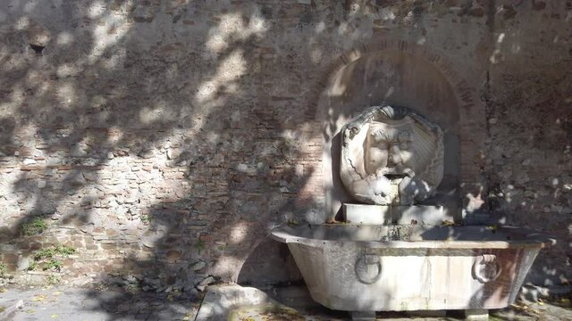 Monumental fountain called Fontana del Mascherone di Santa Sabina located in Rome, slow motion with dolly forward move combined with pan move.