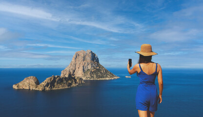 Asian woman selfie in front of the islet of Es Vedra in Spain by the sea in summer in Cala dhort