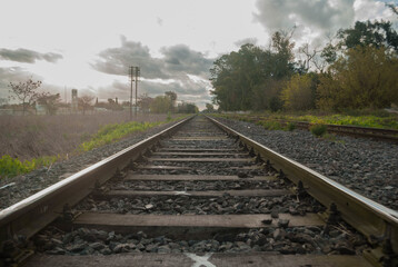 View of train rails under cloudy sky