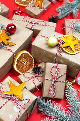 Many Christmas gift boxes on red background. Eco present handmade wrapped craft paper New year diy