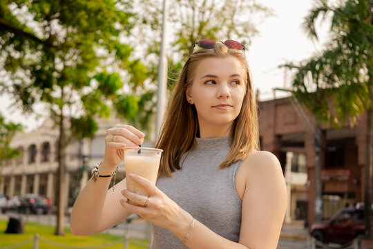 Young beautiful Brazilian female drinking Somo, a Bolivian drink