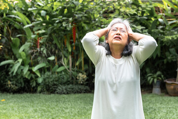 Asian elderly woman Having a headache Because it is a disease related to pressure and migraine,...