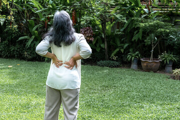 Elderly woman have gray hair are suffering from the lumbar with green nature background, to...
